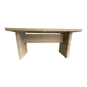 A rectangular outdoor dining table made of weatherproof wicker with a powder-coated aluminium frame and a safety glass top.