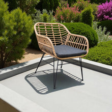 ATRANI wicker patio chair with a black cushion on a patio - DECOR STAR