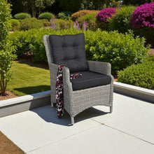 Gray wicker chair with dark cushions on a patio - DECOR STAR