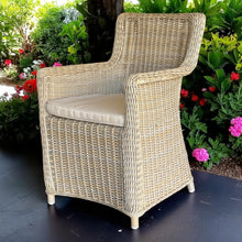 ASHBURTON natural kubu wicker chair with a beige cushion on a patio - DECOR STAR