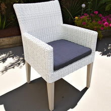 CHADSTONE White wicker chair with a dark cushion on a patio - DECOR STAR
