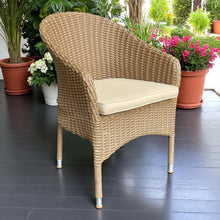 CLIFTON HILL brown wicker chair with a cream cushion on a dark wooden floor - DECOR STAR