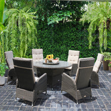 MCKINNON Outdoor patio set with wicker recliner chairs and a round dining table on a stone patio - DECOR STAR