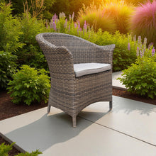 MORDIALLOC brown wicker chair with a cream cushion on a patio - DECOR STAR