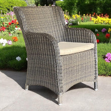 ORMOND dark brown wicker armchair with a beige cushion in a garden - DECOR STAR