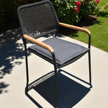 PARKDALE outdoor chair with black cord woven backrest and wooden armrest, grey cushion on a concrete surface - DECOR STAR