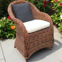 ROSANNA wicker armchair with white cushions on a patio - DECOR STAR