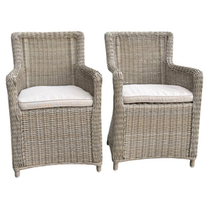 Two wicker chairs with beige cushions 